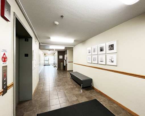 A hallway with a bench and pictures on the wall.