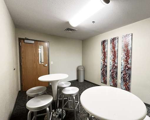 A room with a round table and stools.