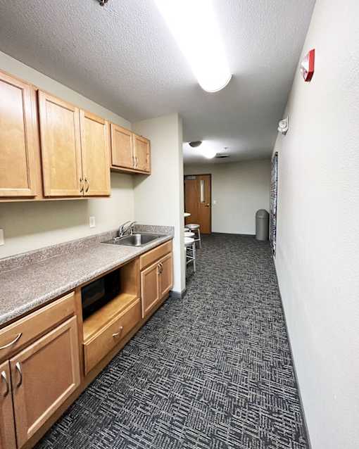 A kitchen with wooden cabinets and a grey counter top.