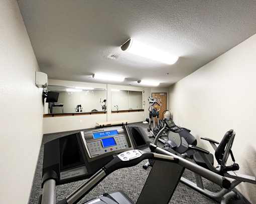 A gym with a treadmill and exercise bike.