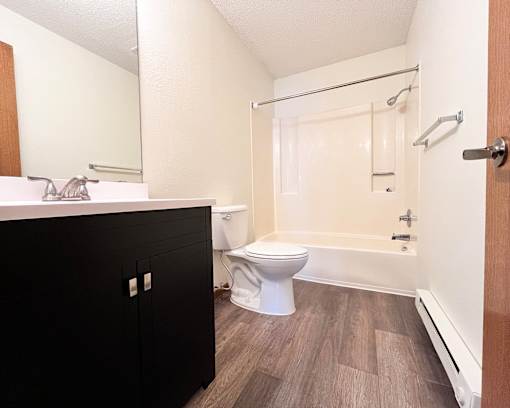 A bathroom with a toilet, sink, and bathtub.