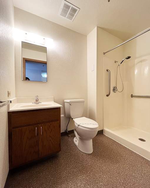 A bathroom with a toilet, sink, and shower.