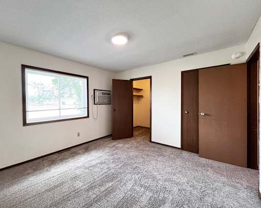 A room with a carpeted floor and a window.