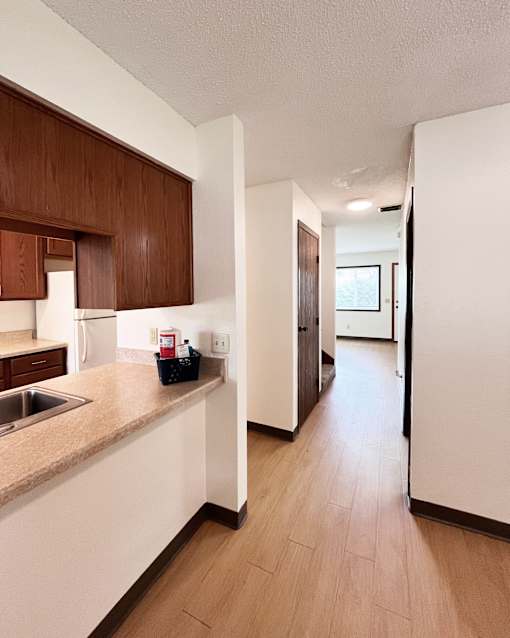 A kitchen with brown cabinets and a counter top.