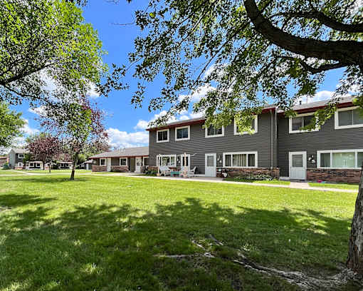 A row of houses with green lawns in front.