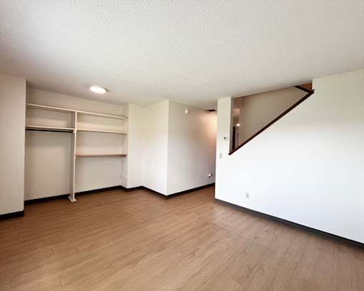 A room with a white wall and a wooden floor.