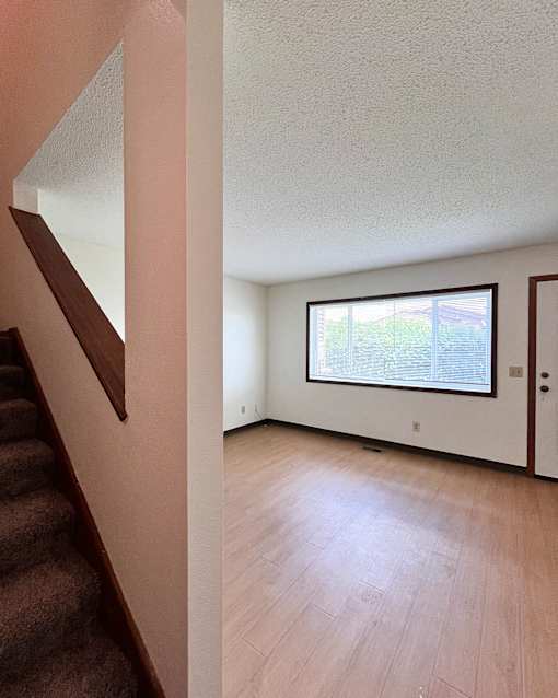 A room with a window and a staircase.