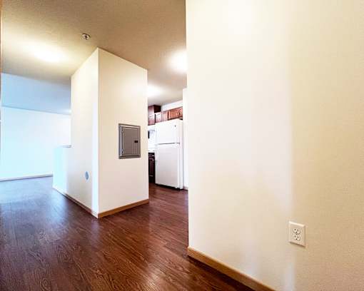 A room with a white wall and a wooden floor.