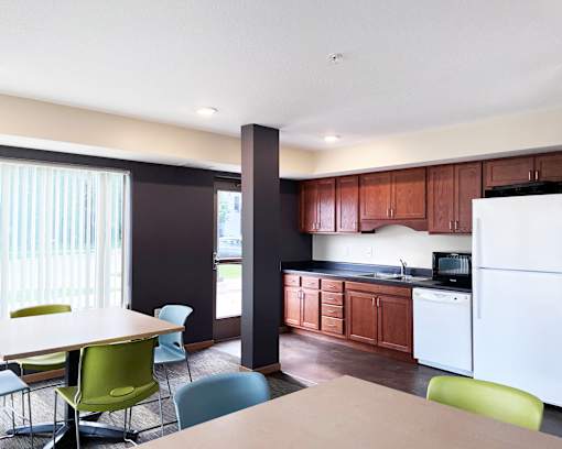 A kitchen with brown cabinets and a white refrigerator.