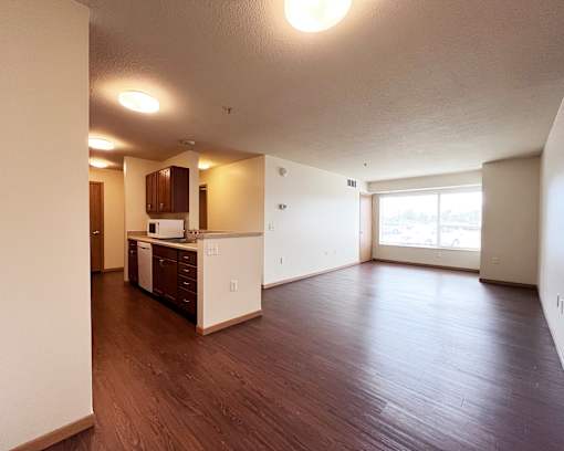 A kitchen with wooden floors and white walls.