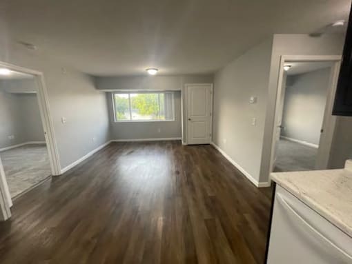 A room with wooden flooring and white walls.