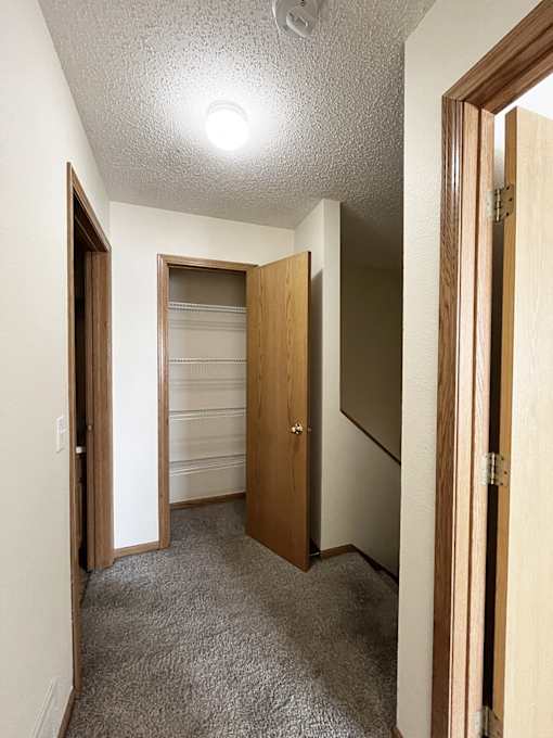 a walk in closet with a mirrored closet door and a door to a closet