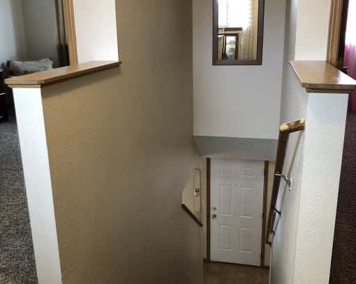a door in a hallway with a mirror above it
