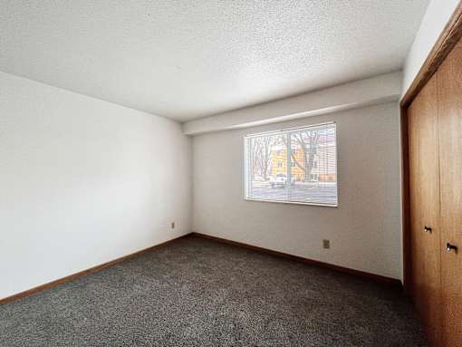 A room with a window showing a street view outside.