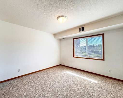 A room with a window and a ceiling light.