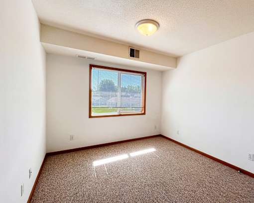 A room with a window and a ceiling light.