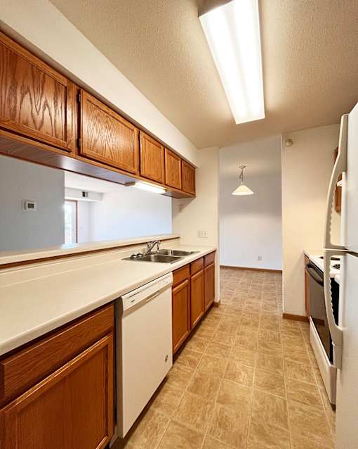 A kitchen with wooden cabinets and white appliances.