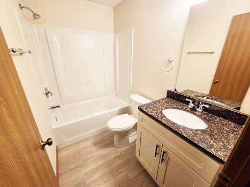 A bathroom with a white tub, sink, and toilet.