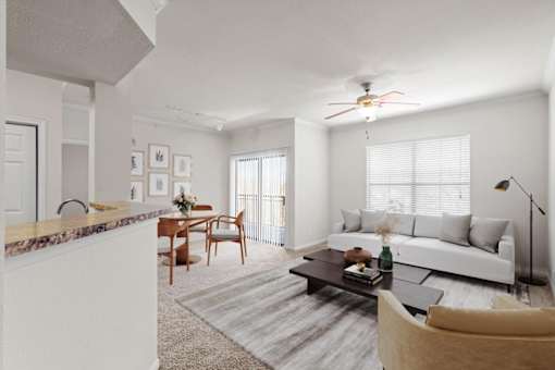 A living room with a ceiling fan, a large window, and a patio entrance in the dining room. at Crescent Apartment Homes, Lenexa, Kansas
