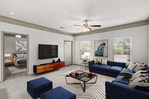 a living room with a couch coffee table and a tv on the wall at Stonepost Crossing Apartments, Overland Park, Kansas