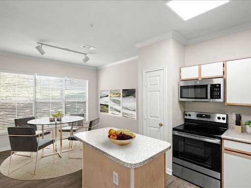 A kitchen and dining area with large windows, track lighting, stainless steel microwave and appliances, pantry closet, and a kitchen island. at Crescent Apartment Homes, Kansas, 66219