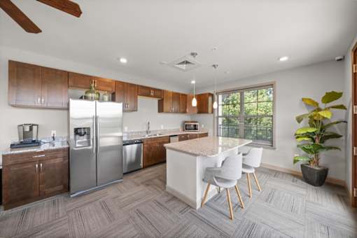 A modern kitchen with a white island and stainless steel appliances. at The Dorset, Kansas City, MO