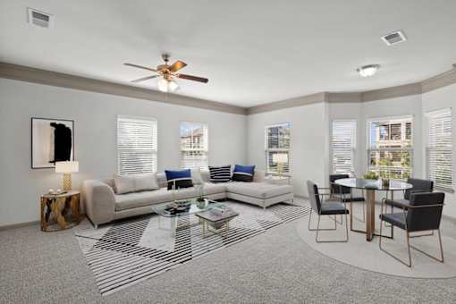 a living room with a couch a table and a ceiling fan at Stonepost Crossing Apartments, Overland Park, KS, 66213