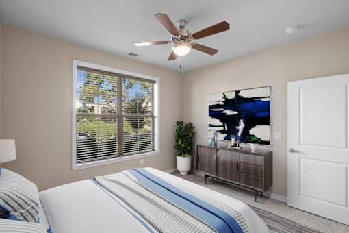 a bedroom with a large window and a ceiling fan at The Dorset, Kansas City, 64112