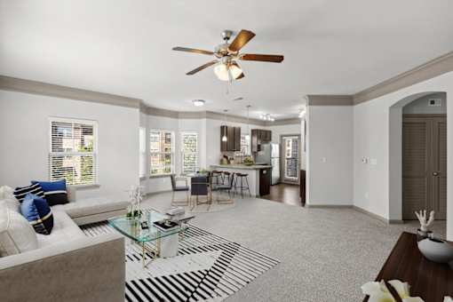 a living room with a couch a table and a ceiling fan at Stonepost Crossing Apartments, Overland Park, 66213