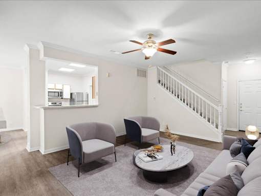 A living room with a ceiling fan and a staircase. at Crescent Apartment Homes, Lenexa, 66219