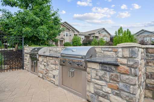 A stone wall with a grill on top at Stonepost Crossing Apartments, Overland Park, KS, 66213