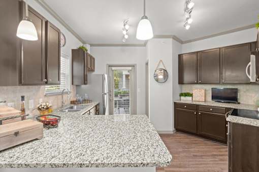 a kitchen with a large island in the middle of it at Stonepost Crossing Apartments, Overland Park, KS, 66213