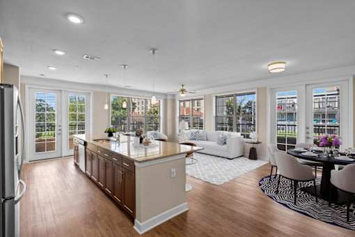 a kitchen with a center island next to a living room with a couch and a table at The Dorset, Kansas City, Missouri