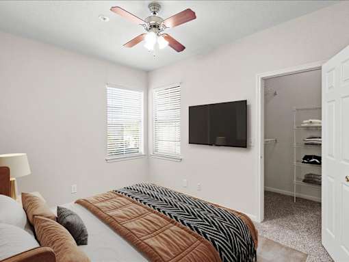 A bedroom with a ceiling fan and large walk in closet. at Crescent Apartment Homes, Lenexa, 66219