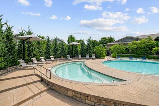 A barbecue grill is on a stone patio at Stonepost Crossing Apartments, Overland Park
