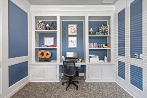 A room with a desk and a chair in front of a wall with shelves. at Crescent Apartment Homes, Kansas, 66219