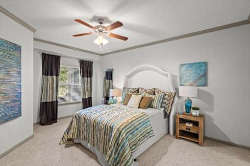 a bedroom with a bed and a ceiling fan at Stonepost Crossing Apartments, Overland Park, KS