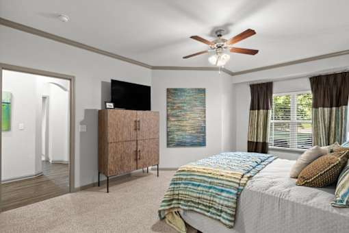 a bedroom with a bed and a ceiling fan at Stonepost Crossing Apartments, Overland Park, KS