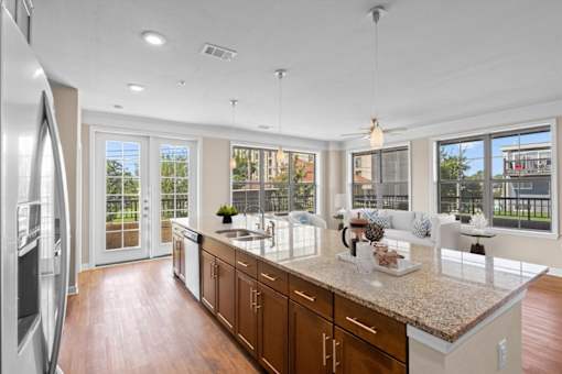 a kitchen with a large island next to a living room at The Dorset, Kansas City, MO