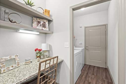 a dining room with a table and chairs and a laundry room in the background at Stonepost Crossing Apartments, Kansas, 66213