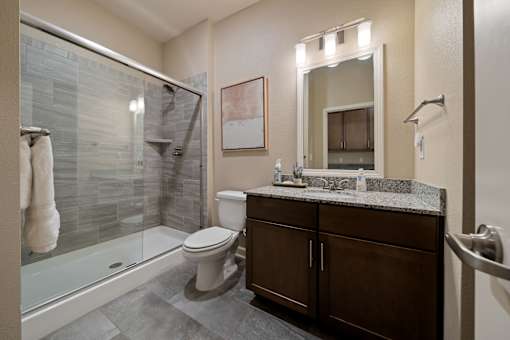 Guest suite bathroom at The Dorset featuring walk-in glass shower, vanity, and modern finishes