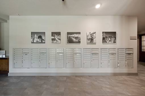 Resident mailroom at The Dorset with organized wall of individual mailboxes and decorative wall art