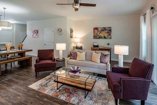 A living room with a couch, two chairs, and a coffee table.