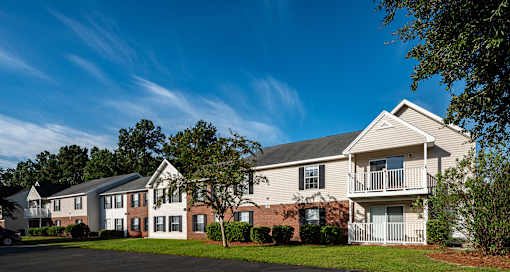 A large apartment complex with a green lawn in front.