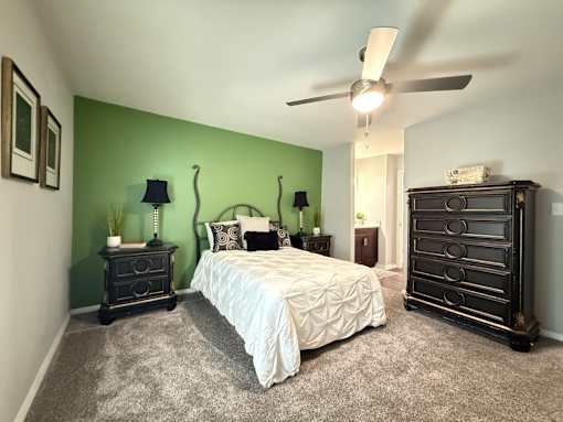 A bedroom with a bed, dresser, and nightstand.