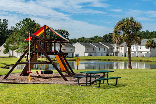 A playground with a slide and a picnic table at The Islands in Charleston SC