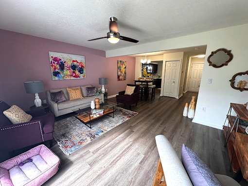 A living room with a purple couch and a coffee table.