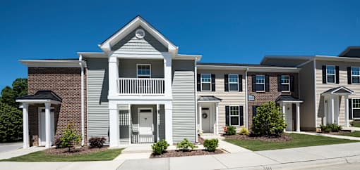 A row of houses with a clear blue sky above them.