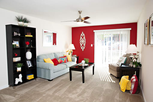 Spacious living room with red accent wall.