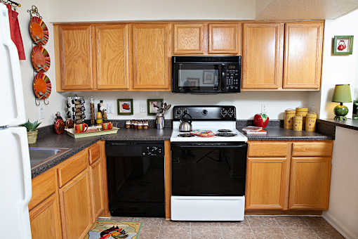 A kitchen with wooden cabinets and black appliances.